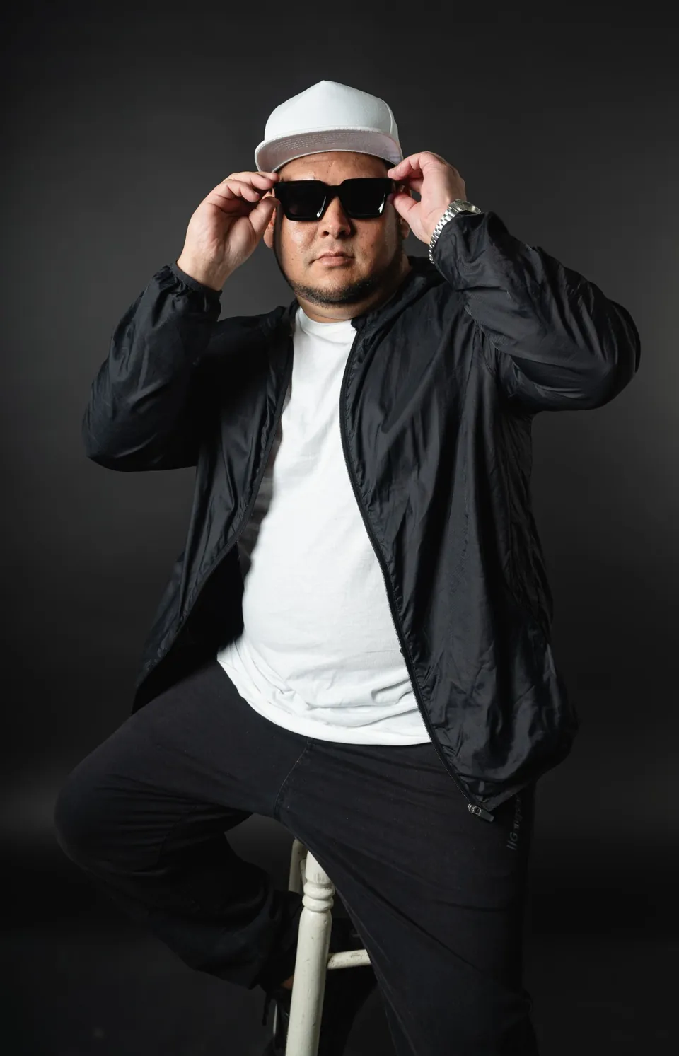 Ajustándose los lentes, gorra blanca